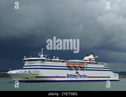 Symbolbild FÅ hre Cap FinistÂre der Brittany Ferries, markantes blau-weiÂß-rotes Design, groÂßer Schornstein, mehrere Rettungsboote an der Seite, bewÅlkter stÅrmischer Himmel, vorbereitet fÅr berfahrten zwischen Frankreich und FahrzeugfÅ, gerÅ umiges Oberdeck, moderner Rumpf, robuste Bauweise fÅr raue See, franzÅsische Flagge am Mast, Bug leicht abgenutzt, bekannte Route nach Portsmouth, Teil der Flotte GroÂßbritannien, Passagier- und fÅr LangstreckenÅberfahrten hre, umfangreiche Kabinen, umfangreiche Fährangebote von Brittany Stockfoto