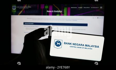 Deutschland. Juni 2024. In dieser Fotoabbildung hält ein Mann ein Smartphone mit dem Logo der malaysischen Institution Bank Negara Malaysia (BNM) vor der Webseite. (Foto von Timon Schneider/SOPA Images/SIPA USA) *** ausschließlich für redaktionelle Nachrichten *** Credit: SIPA USA/Alamy Live News Stockfoto