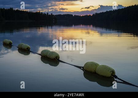 Bojen, die während des Sonnenuntergangs im Wasser schwimmen Stockfoto