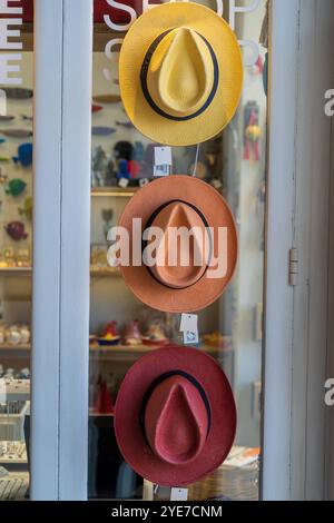 Trio of Hüte auf dem Display: Gelb, braun und lila in Storefront Glass Stockfoto