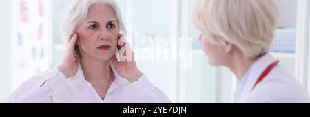 Reife Frau klagt über akuten Kopfschmerz im Leichtbüro Stockfoto