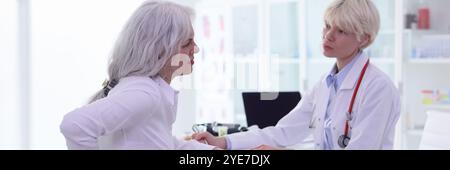 Ältere Klientin klagt über Schmerzen in den Nieren beim Arzt Stockfoto