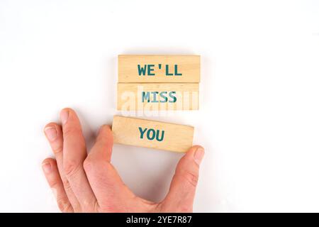 Geschäftskonzept. Konzeptionelle Phrase, Worte, Text, DEN WIR VERMISSEN WERDEN, geschrieben auf Holzstangen, die von Hand angelegt wurden. Stockfoto