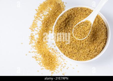 Ungekochter Bulgur-Weizen in einem Löffel und Teller von oben Stockfoto