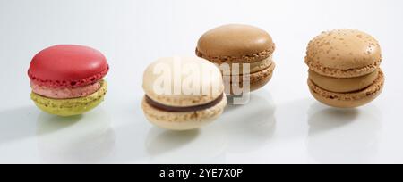 Vier verschieden farbige Macarons vor weißem Hintergrund, Studioaufnahme Stockfoto