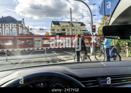 Gesperrter Bahnübergang, geschlossene Absperrung, Andreaskreuz, Ampeln, vorbeifahrende S-Bahn-Züge, Radfahrer und Autofahrer warten, Drachenfelsstraße cro Stockfoto