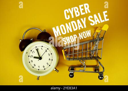 Cyber Monday Verkaufstext mit Wecker und Einkaufswagen auf gelbem Hintergrund Stockfoto