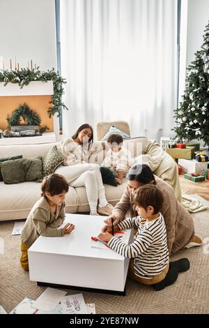 Eine fröhliche asiatische Familie versammelt sich in einem modernen Wohnzimmer und genießt festliche Momente rund um ihren Weihnachtsbaum. Stockfoto