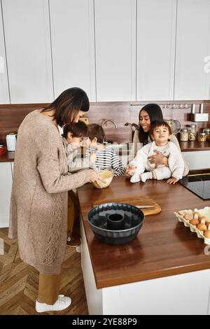 Eine fröhliche Familie bereitet in ihrer gemütlichen Küche Urlaubsfreuden zu, mit Kindern, die sich mit dem Backen beschäftigen. Stockfoto