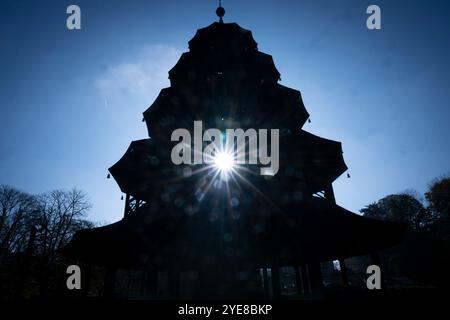 München, Deutschland. 30. Oktober 2024. Die Sonne scheint durch den Chinesischen Turm im Englischen Garten. Der Deutsche Wetterdienst hat seinen Monatsbericht für Oktober veröffentlicht. Quelle: Peter Kneffel/dpa/Alamy Live News Stockfoto