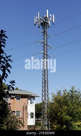 Charlotte, NC, USA-Okt. 20, 2024: Hoher zellulärer und elektrischer Turm auf dem Hof des Wohnhauses. 10X16-Format. Stockfoto