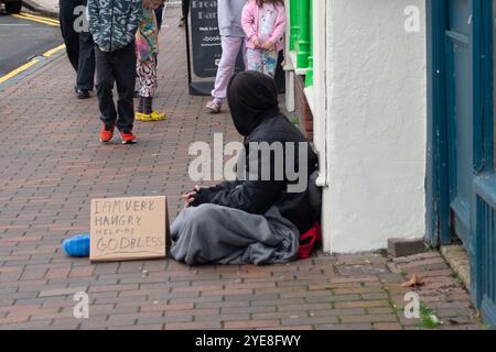 Chesham, Großbritannien. Oktober 2024. Ein Mann bettelt vor der Chiltern Food Bank in der Chesham High Street, Buckinghamshire. Bundeskanzlerin Rachel Reeves wird den Haushalt am Mittwoch, den 30. Oktober 2024, bekanntgeben. Es wird erwartet, dass die Kapitalertragssteuer steigen wird, was bedeutet, dass der Kauf von Vermietern, um Vermieter zu überlassen, ihr Immobilienportfolio als eine Angelegenheit der Dringlichkeit auflädt. Der Mindestlohn wird ebenfalls steigen. Quelle: Maureen McLean/Alamy Live News Stockfoto