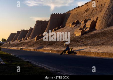 Der Blick auf den Sonnenuntergang auf die zinnenbedeckte Mauer von Chiwa der Innenstadt, genannt Itchan Kala. Chiwa ist eine Stadt und ein Stadtteil in der Region Chorazm in Usbekistan. Die Stadt Stockfoto