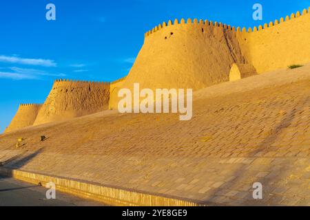 Der Blick auf den Sonnenuntergang auf die zinnenbedeckte Mauer von Chivas Innenstadt, genannt Itchan Kala. Chiwa ist eine Stadt und ein Stadtteil in der Region Chorazm in Usbekistan. Stockfoto