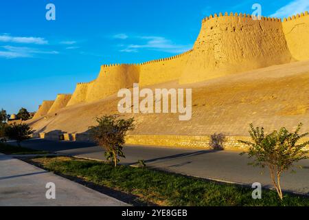 Der Blick auf den Sonnenuntergang auf die zinnenbedeckte Mauer von Chivas Innenstadt, genannt Itchan Kala. Chiwa ist eine Stadt und ein Stadtteil in der Region Chorazm in Usbekistan. Stockfoto