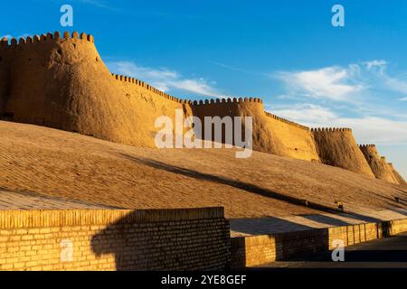 Der Blick auf den Sonnenuntergang auf die zinnenbedeckte Mauer von Chivas Innenstadt, genannt Itchan Kala. Chiwa ist eine Stadt und ein Stadtteil in der Region Chorazm in Usbekistan. Stockfoto