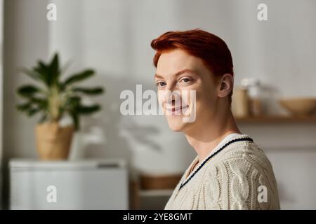 Ein junger Mann mit roten Haaren lächelt fröhlich, während er sich auf die Weihnachtsfeier vorbereitet. Stockfoto