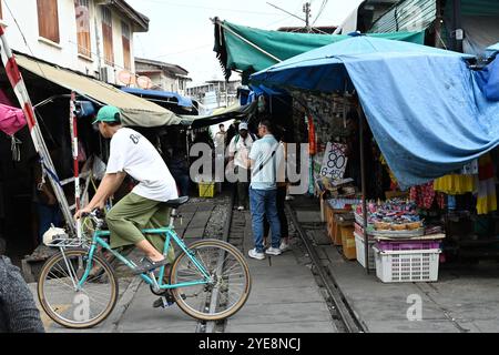 Eisenbahnmarkt Thailand , Ein Mann im Fahrrad, der die Gleise überquert in Railway Market , Maeklong Railway , Thailand , Bangkok , Asien Stockfoto