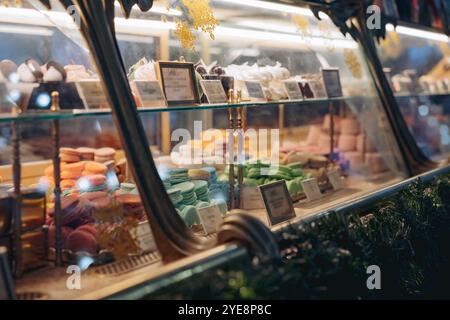 französische Gebäckstücke im Süßwarenladen, süße Desserts, Makronen Kuchen auf der Theke hinter dem Glas. Bild mit selektivem Fokus Stockfoto