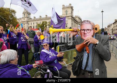 London, UK, 30. Oktober 2024. Ein Mann trägt eine Kier Starmer-Masken bei einer WASPI-Frauendemonstration am Parlamentsplatz am Budgettag. Während die Labour-Kanzlerin Rachel Reeves das erste Labour-Budget für 14 Jahre ausgibt, finden Proteste vor den Kammern des Parlaments statt. Die erste Kanzlerin des Vereinigten Königreichs hat wiederholt vor hohen Steuererhöhungen und Ausgabenkürzungen von bis zu 40 Milliarden Pfund gewarnt. WASPI-Demonstrantinnen besetzen den Parlamentsplatz, während das Budget den Abgeordneten und dem Land zur Verfügung gestellt wird. Quelle: James Willoughby/ALAMY Live News Stockfoto