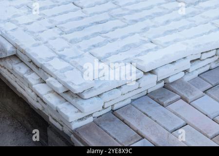 Steinhaufen aus Dolomitgesteinen. Leichte Backsteinpfähle für ein Bauprojekt, bereit für Bau und Dekoration. Stockfoto