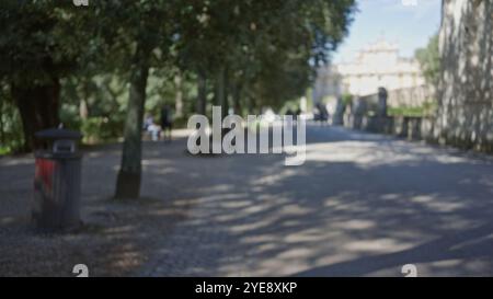 Verschwommener Blick auf die Gärten der Villa borghese in rom mit Menschen, die draußen zwischen Bäumen und Schatten spazieren gehen, schaffen eine friedliche, entspannte Atmosphäre, die grüner ist Stockfoto