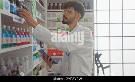 Hispanischer Apotheker mit Bart mit Tablette in der modernen Drogerie Stockfoto