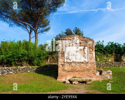 Tempel der Söhne von Pompeius Justus in der alten Via Appia, erbaut von Appius Claudius Caecus, dem römischen Zensor zu Beginn des 4. Jahrhunderts v. Chr., um Truppen außerhalb der kleineren Region des Großraums Rom (4. Jahrhundert v. Chr.) zu transportieren. Das Grab hat seinen Namen von der Figur, die auf dem großen Epigraph in Vers erwähnt wird: „Ein armer Vater, Sesto Pompeo, trauert um den unreifen Tod eines Sohnes und einer Tochter. Er hoffte, ihnen durch das Gesetz der Natur bis zum Grab vorzugehen, stattdessen musste er unglücklich das Feuer entzünden. Er lobt sie und fleht die Götter an, bald wieder mit ihnen vereint zu werden. - Rom, Italien Stockfoto