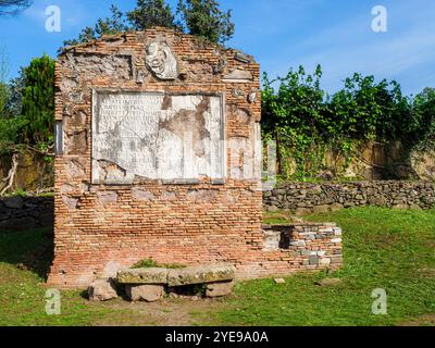 Tempel der Söhne von Pompeius Justus in der alten Via Appia, erbaut von Appius Claudius Caecus, dem römischen Zensor zu Beginn des 4. Jahrhunderts v. Chr., um Truppen außerhalb der kleineren Region des Großraums Rom (4. Jahrhundert v. Chr.) zu transportieren. Das Grab hat seinen Namen von der Figur, die auf dem großen Epigraph in Vers erwähnt wird: „Ein armer Vater, Sesto Pompeo, trauert um den unreifen Tod eines Sohnes und einer Tochter. Er hoffte, ihnen durch das Gesetz der Natur bis zum Grab vorzugehen, stattdessen musste er unglücklich das Feuer entzünden. Er lobt sie und fleht die Götter an, bald wieder mit ihnen vereint zu werden. - Rom, Italien Stockfoto