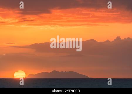 Insel Gorgona und Blick auf die untergehende Sonne von der Küste von Livorno. Meereslandschaft Sonnenuntergang im Mittelmeer, Toskana, Italien, Europa Stockfoto