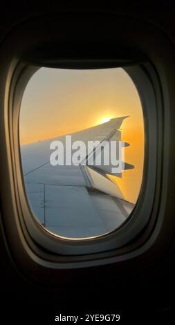 Sonnenaufgang aus dem Flugzeugfenster mit Blick auf den Flügel Stockfoto