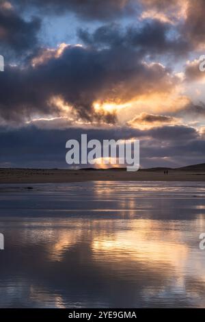 Ein Paar spaziert bei stürmischen Bedingungen am Scarista Beach bei Sonnenuntergang, Isle of Harris, Äußere Hebriden, Schottland, Großbritannien Stockfoto