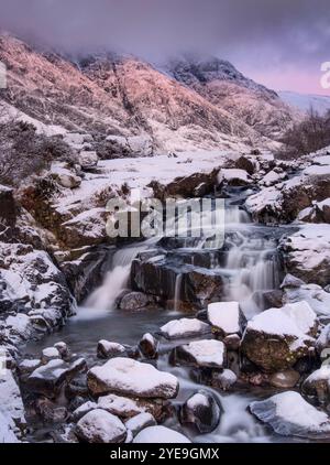 Letztes Licht auf den Clachaig Falls, begleitet von Aonach Eagach und Meal Dearg im Winter, Glencoe, Scottish Highlands, Schottland, Großbritannien Stockfoto