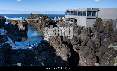 Touristen, die von einem erhöhten Fußweg entlang der Küste von Porto Moniz auf der Insel Madeira, Portugal; Porto Moniz, Madeira, Portugal Stockfoto