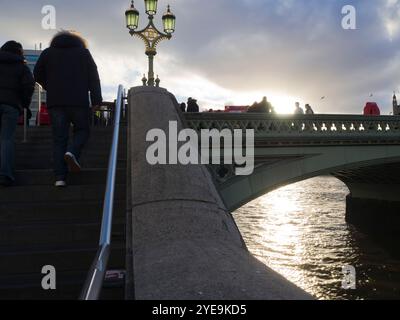 Hintergrundbeleuchteter Blick auf die Westminster Bridge vom Themsepfad mit beleuchteter Laternenlaterne und Treppenklettern, London, Großbritannien; London, England Stockfoto