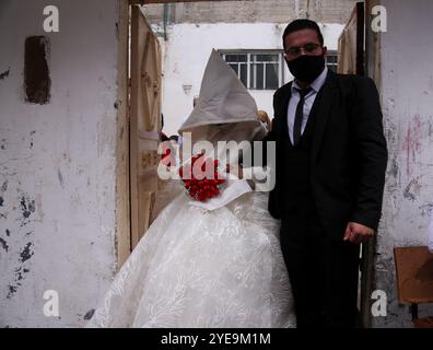 Gaza-Stadt, Palästina. September 2020. Ein palästinensisches Paar heiratet in Gaza-Stadt in einer kleinen Hochzeitszeremonie, die auf ihre engsten Familienmitglieder beschränkt ist, wobei soziale Distanzierung und Gesichtsmasken Teil der Veranstaltung sind. Seit dem 24. August, als erstmals COVID-19-Fälle bei der Bevölkerung des Gazastreifens festgestellt wurden, ist die Zahl der Virusinfektionen im palästinensischen Gebiet drastisch gestiegen. Die Behörden haben mit der steigenden Zahl von Fällen im Gazastreifen zu kämpfen, einem der bevölkerungsreichsten Gebiete der Welt und einer überlasteten und zu geringen Gesundheitsinfrastruktur Stockfoto