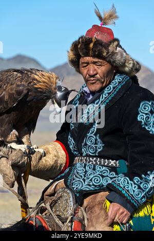 Mongolischer Adlerjäger zu Pferd mit dem Goldenen Adler (Aquila chrysaetos) beim Adlerfest in der Mongolei; Olgii, Mongolei Stockfoto