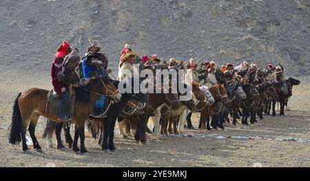 Mongolische Adlerjäger zu Pferd mit Goldenen Adlern (Aquila chrysaetos) beim Adlerfest in der Mongolei; Olgii, Mongolei Stockfoto