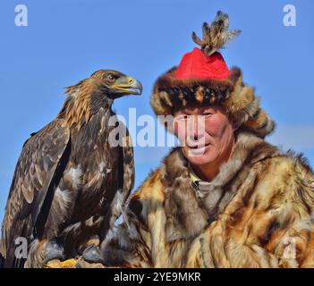 Mongolischer Adlerjäger mit Goldenadler (Aquila chrysaetos) beim Adlerfest in der Mongolei; Olgii, Mongolei Stockfoto