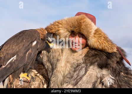 Mongolischer Adlerjäger mit Goldenadler (Aquila chrysaetos) beim Adlerfest in der Mongolei; Olgii, Mongolei Stockfoto