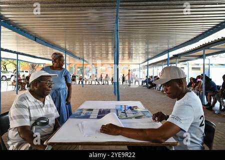 Gaborone, Botswana. 30. Oktober 2024. Die Wähler warten vor einem Wahllokal in Gaborone, Botswana, 30. Oktober 2024. Botswanas Bürger gingen am Mittwoch zu den Wahllokalen, um ihre Stimmzettel für neue Parlamentarier und lokale Behörden abzugeben. Quelle: Han Xu/Xinhua/Alamy Live News Stockfoto