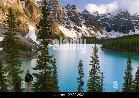 Weibliche Wanderer auf Felsen mit Blick auf den Moraine Lake und die Ten Peaks im Banff National Park; Alberta, Kanada Stockfoto