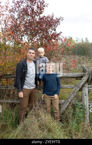 Porträt eines Vaters, der mit seinen beiden Söhnen in einer ländlichen Umgebung im Herbst posiert, Beckwith Township am Carleton Place im Ottawa Valley, Ontario, Kanada Stockfoto