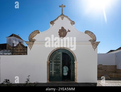 Frau steht in der Tür einer Kirche in Faro, Portugal. Faro ist die Hauptstadt der Algarve im Süden Portugals; Faro, Portugal Stockfoto