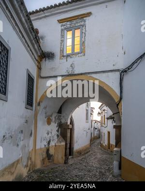 Verwitterte Gebäude und Kopfsteinpflasterstraße in der Altstadt von Evora, Portugal. Evora ist die Hauptstadt von Portugals südzentralem Alentejo... Stockfoto