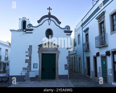 Kleines weißgetünchtes Kirchengebäude in der Stadt Tavira, Portugal. Tavira ist eine kleine Stadt an der portugiesischen Algarve und erstreckt sich über den Gilao River Stockfoto