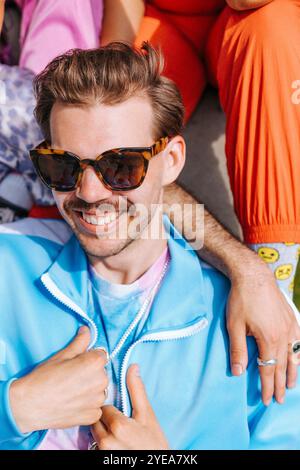 Hochwinkelansicht eines lächelnden jungen Mannes mit Sonnenbrille an sonnigen Tagen Stockfoto