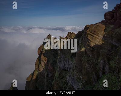 Ein einsamer Wanderer blickt auf einen Gipfel auf dem Pico do Areeiro, dem dritthöchsten Gipfel der Insel Madeira, Portugal Stockfoto