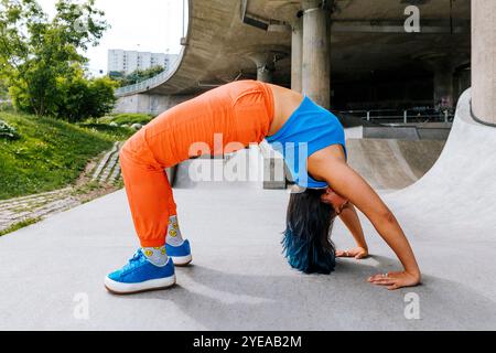 Sportliche Frau, die auf einer Überführung unter der Brücke Sport macht Stockfoto