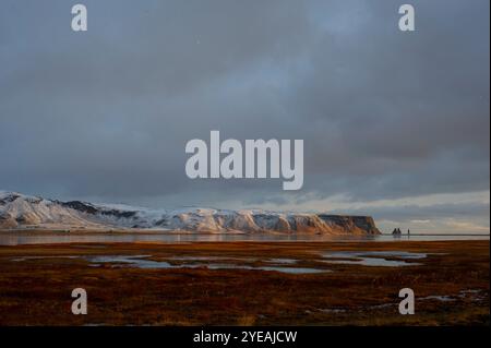 Blick auf die schneebedeckten Berge an der Südküste Islands bei Sonnenuntergang im Winter; Dyrhólaey, Katla Geopark, Island Stockfoto